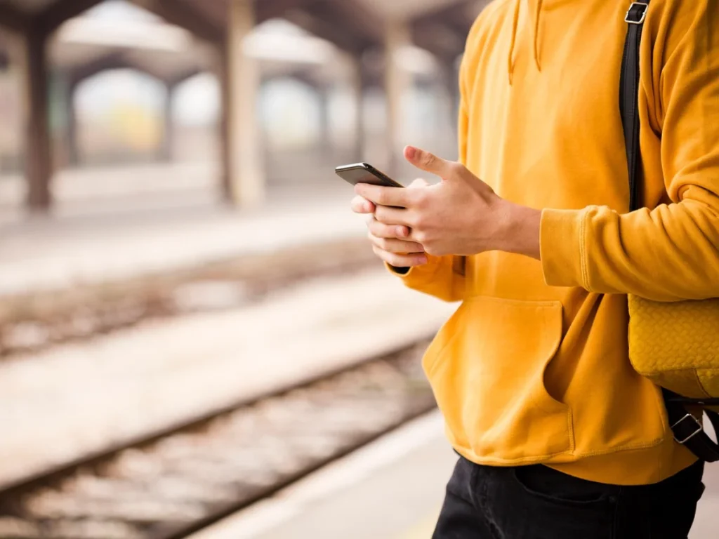駅のホームでスマホ検索をする人