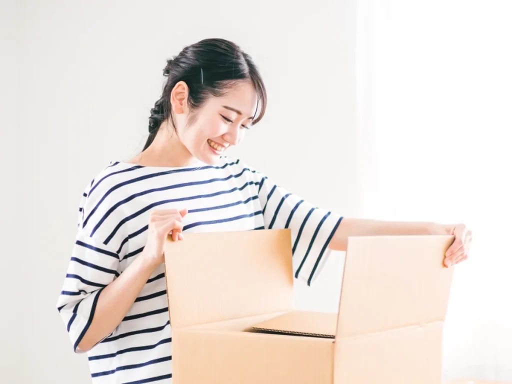 段ボール箱の蓋に手をかけた女性